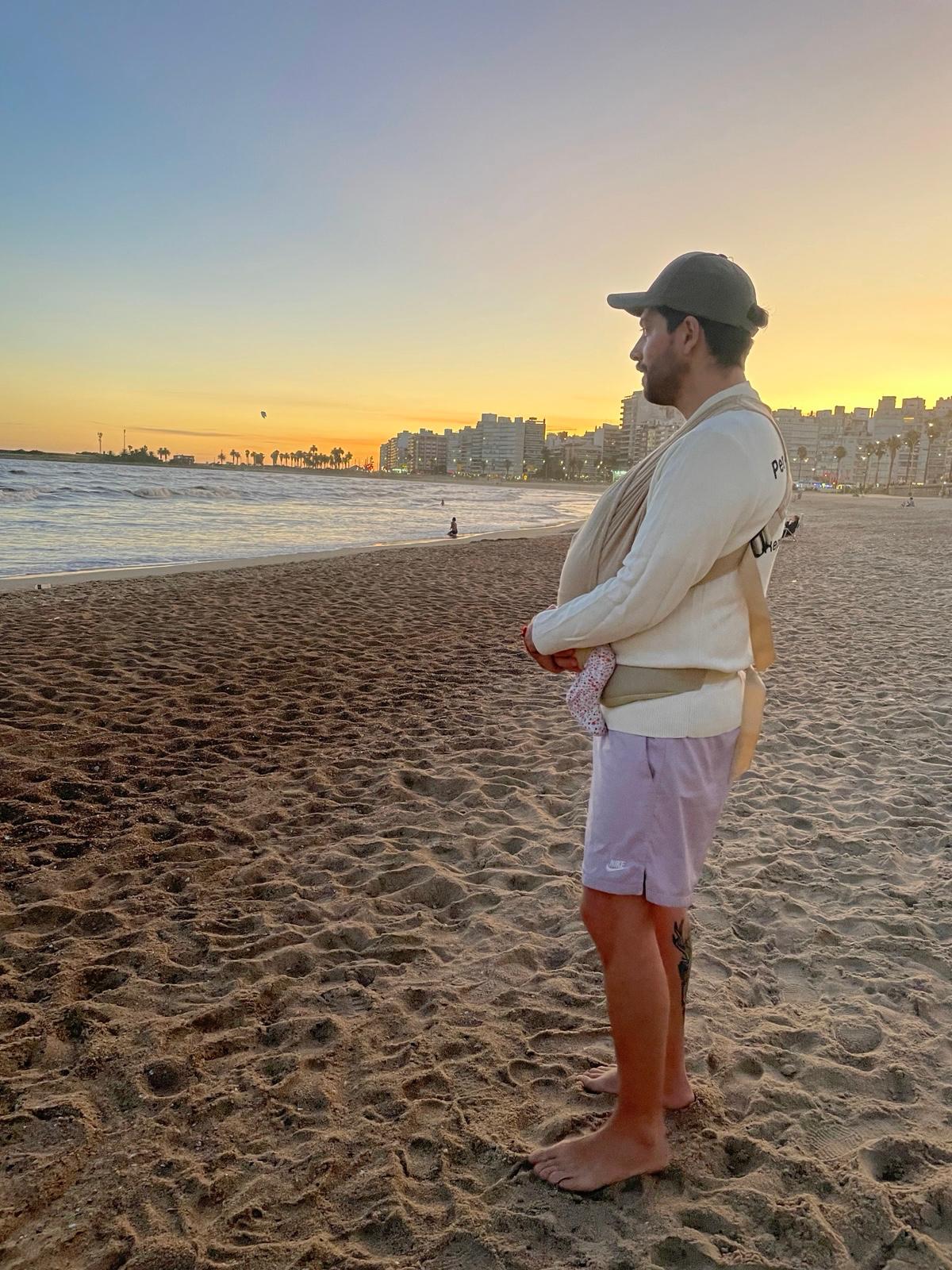 Danilo Rodríguez mirando el horizonte con su bebé en porteo
